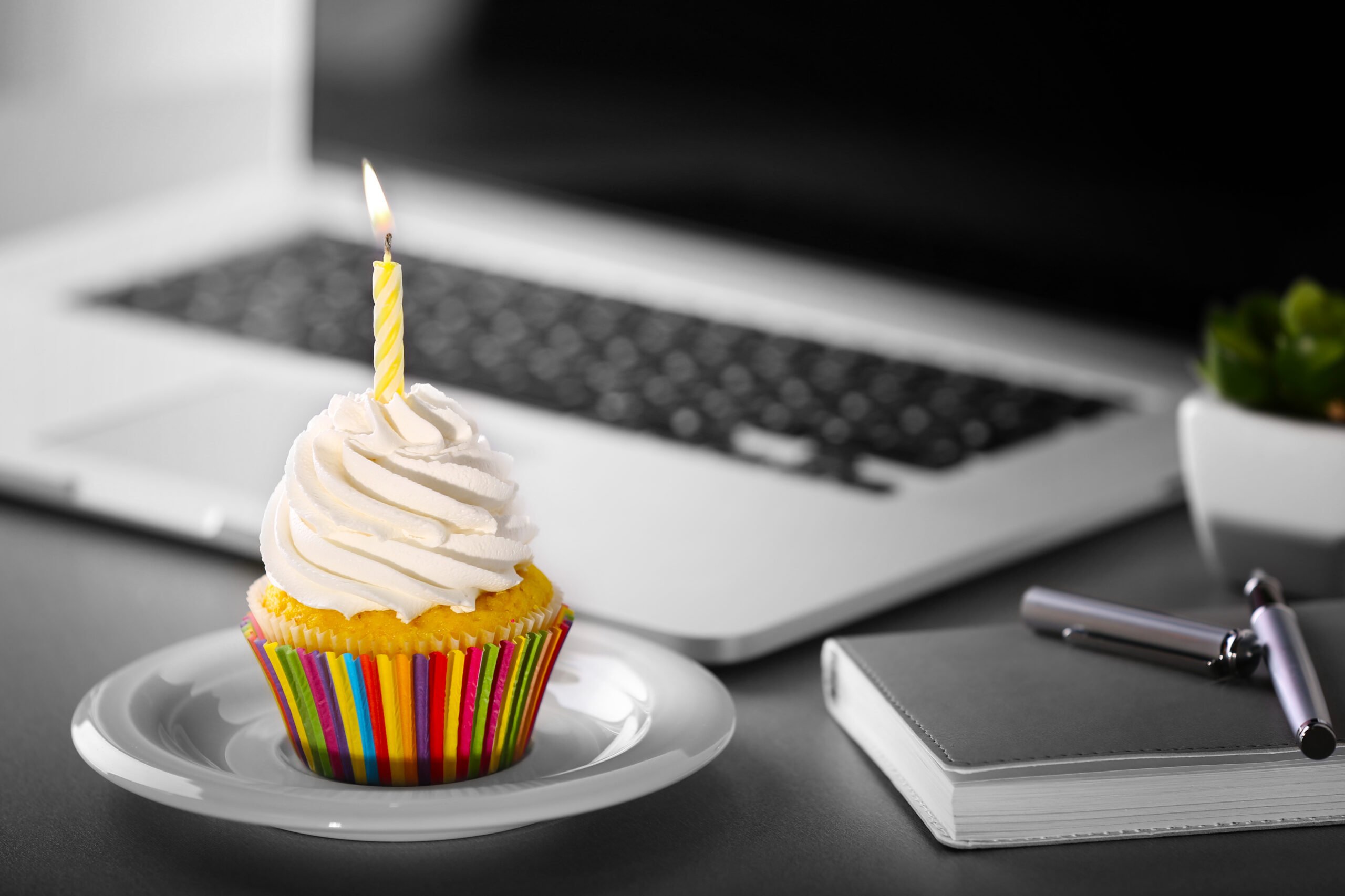 Work anniversary cupcake next to laptop