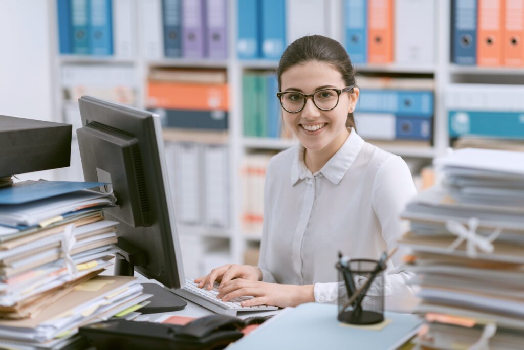 Administrative professional working in a room full of binders